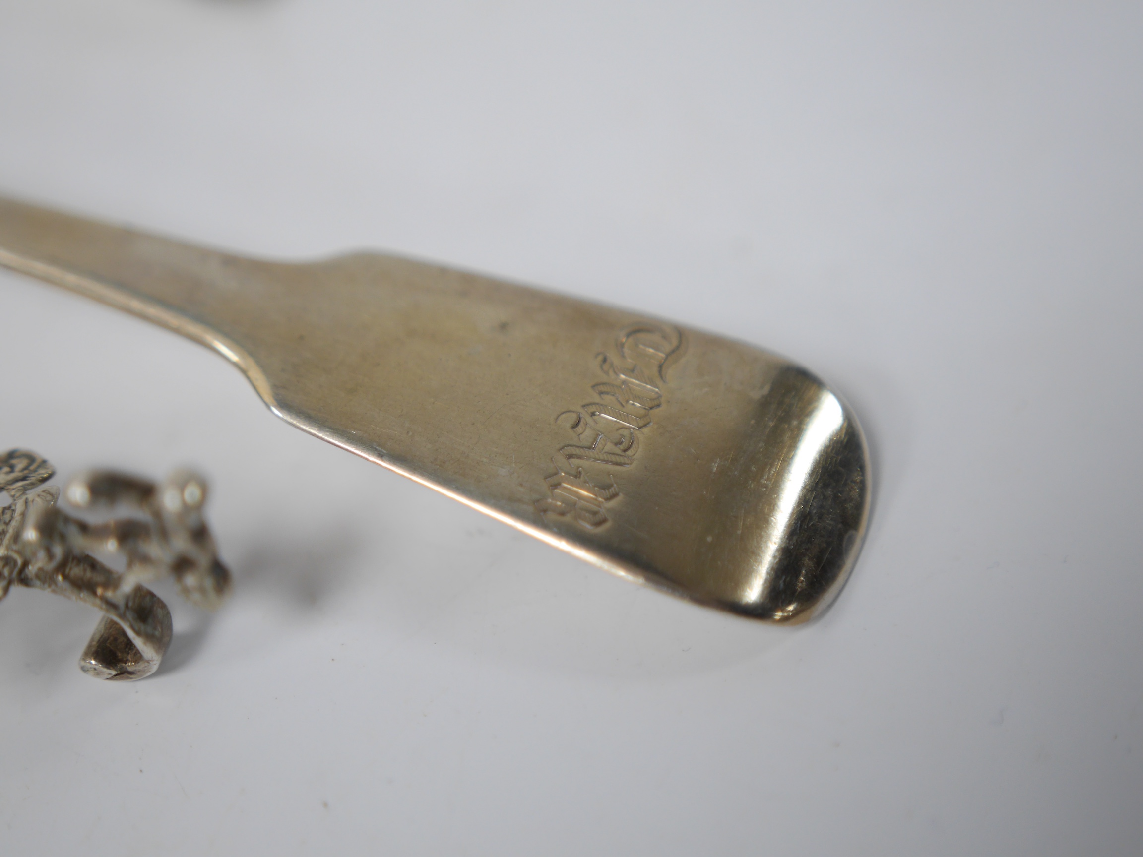 A late 19th century continental silver caddy spoon, with figural terminal, import marks for Sheffield, 1894, together with four assorted 19th century spoons including three table spoons and a sauce ladle, various dates a